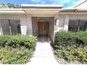 Front entrance with a decorative security door, surrounded by desert landscaping, and mature shrubbery at 2480 Domingo St, Las Vegas, NV 89121