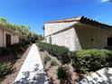 View of the side of the home, showing the walkway and desert landscaping on a bright, sunny day at 2480 Domingo St, Las Vegas, NV 89121