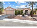 Beautifully landscaped single-story home showcasing a charming entrance and a well-kept front yard with mature trees at 2605 Lotus Hill Dr, Las Vegas, NV 89134