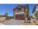Two-story home featuring brick driveway, desert landscaping, and red shutters and garage door at 2617 Snapdragon Falls Ave # 100, North Las Vegas, NV 89081