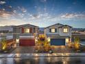 Side-by-side view of two-story homes with brick driveways, desert landscaping, shutters, and garages at 2617 Snapdragon Falls Ave # 100, North Las Vegas, NV 89081
