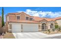 A charming two-story home with a tile roof, arched entryway, and attached two-car garage is beautifully displayed at 2713 Beachside Ct, Las Vegas, NV 89117