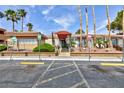 Desert Shores Villas building entrance with red awning, desert landscaping, and ample parking at 3151 Soaring Gulls Dr # 1053, Las Vegas, NV 89128