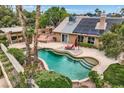 Stunning backyard pool with spa, lush landscaping, patio area with lounge chairs, and solar panels at 3619 Bixbee Ct, Las Vegas, NV 89129