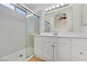 Bathroom with a walk-in shower, a mirror, and white cabinets at 3808 Lilac Haze St, Las Vegas, NV 89147