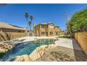 Gorgeous backyard featuring a lagoon-style pool with rock accents, lush greenery, and privacy fencing at 4 Bishopsgate Ter, Henderson, NV 89074