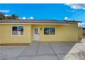The backyard is simple and clean, featuring yellow walls and concrete flooring at 4419 Fairmont Cir, Las Vegas, NV 89147