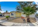 Yellow house with attractive xeriscaping, accented by mature palm and desert trees at 4419 Fairmont Cir, Las Vegas, NV 89147