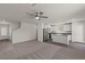 Open-concept living area with carpeted floors and an adjacent kitchen area at 4928 Canna Lily St, Las Vegas, NV 89122