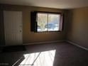 Bright living area featuring neutral walls, carpet flooring, a front door and a large window with dark shutters at 500 S 13Th St # C6, Las Vegas, NV 89101