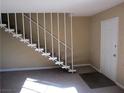 Entryway with a view of the staircase featuring white railing and front door, bathed in natural light at 500 S 13Th St # C6, Las Vegas, NV 89101