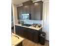 Kitchen with modern appliances, dark wood cabinets, and stone countertops at 5404 Scandia Lore Ct, Las Vegas, NV 89130