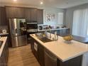 Kitchen island features stone countertops, stainless appliances, and dark wood cabinets at 5404 Scandia Lore Ct, Las Vegas, NV 89130
