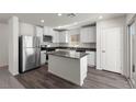 Modern kitchen with white cabinets, stainless steel appliances, and a gray countertop island, offering a clean aesthetic at 6234 Blood Lily Ave, Las Vegas, NV 89122