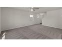 Spacious living room featuring neutral carpet and a ceiling fan at 6245 Blood Lily Ave, Las Vegas, NV 89122
