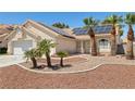 Inviting single-story home featuring solar panels, desert landscaping with palm trees, and a two-car garage at 6328 Yankee Meadow Cir, Las Vegas, NV 89130