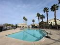 Community pool surrounded by palm trees, providing a resort-like atmosphere at 6459 Rusticated Stone Ave # 103, Henderson, NV 89011