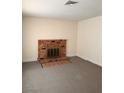 Cozy living room features a classic brick fireplace and updated carpet flooring at 6460 Linda Ln, Las Vegas, NV 89103