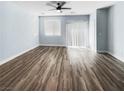 Expansive living room with light walls, hardwood floors, ceiling fan, and sliding door at 6537 Ditmars St, Las Vegas, NV 89166
