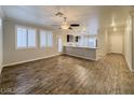 Open living space features wood floors, bright windows with white shutters, and modern ceiling fan at 6777 Wormwood Ln, Las Vegas, NV 89148