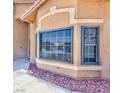 Close up of home exterior featuring a large window and manicured landscaping at 7751 Locke Haven Dr, Las Vegas, NV 89123
