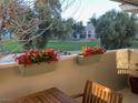 Inviting balcony with wooden table and chairs, enhanced by vibrant red flowers in planter boxes at 778 Oakmont Ave # 312, Las Vegas, NV 89109