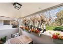 Inviting balcony area with a wooden table, cushioned chairs, and charming red flower boxes at 778 Oakmont Ave # 312, Las Vegas, NV 89109