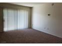 Bright living room featuring neutral carpet and sliding glass doors for ample natural light at 8070 W Russell Rd # 1028, Las Vegas, NV 89113