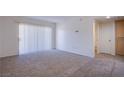 Bright living room with neutral carpet, large sliding glass doors, and white walls at 8070 W Russell Rd # 1028, Las Vegas, NV 89113