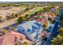 New construction home with a gray roof, surrounded by lush landscaping and a golf course in the neighborhood at 8721 Robinson Ridge Dr, Las Vegas, NV 89117