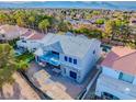 Rear view of the modern new construction home featuring a second-story patio with blue glass panels at 8721 Robinson Ridge Dr, Las Vegas, NV 89117