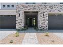 Beautiful entrance with stone accents and a modern black front door at 8721 Robinson Ridge Dr, Las Vegas, NV 89117