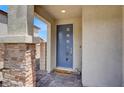 Inviting entryway with a stylish blue front door, stone accents, and 'Welcome' mat at 8870 Sasquatch Run Ave, Las Vegas, NV 89166