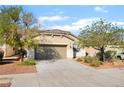 Charming single-story home featuring a desert landscape, a two-car garage, and a concrete driveway at 925 Crescent Falls St, Henderson, NV 89011