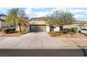 Charming single-story home with desert landscaping, two-car garage and concrete driveway at 925 Crescent Falls St, Henderson, NV 89011