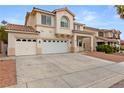 Charming two-story home featuring a three-car garage, landscaped front yard, and a classic desert color palette at 9630 Tuscola Ct, Las Vegas, NV 89148