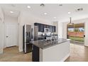 Modern kitchen featuring granite counters, stainless steel appliances, black cabinetry, and backyard access at 9630 Tuscola Ct, Las Vegas, NV 89148
