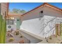 A charming home exterior features a light-blue door and desert landscaping with cacti and a stone walkway at 976 El Camino Way, Boulder City, NV 89005
