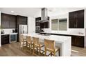 Stylish kitchen features dark cabinets, stainless appliances, a large island with seating, and ample counter space at 9815 Evergreen Pine St, Las Vegas, NV 89166