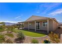 The backyard has desert landscaping, artificial turf, and a covered patio, ideal for outdoor living at 1047 Atkins Ln, Mesquite, NV 89027