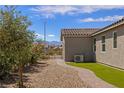 Side view of the house features a tiled roof, desert landscaping, and a stone pathway at 1047 Atkins Ln, Mesquite, NV 89027
