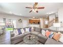 Comfortable living room with gray sectional, ceiling fan, and sliding glass doors to the backyard at 10636 Colter Bay Ct, Las Vegas, NV 89129