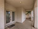 Welcoming covered porch area features double doors with decorative glass inserts and neutral finishes at 1115 Aldenwood Ave, Las Vegas, NV 89123