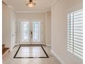 Light-filled foyer boasts tiled floors, decorative glass double-door entrance, and shuttered windows at 1115 Aldenwood Ave, Las Vegas, NV 89123