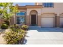Inviting townhome showcasing desert landscaping, a private garage, and a welcoming front door at 1617 Cave Spring Dr, Henderson, NV 89014