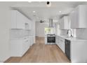 Modern kitchen featuring white cabinets, stainless steel appliances, and wood-look flooring at 1705 Imperial Cup Dr, Las Vegas, NV 89117