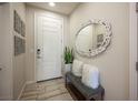 Home entryway with a bench, decorated mirror and wall decor, complemented by tile floors at 2198 Maderno St, Henderson, NV 89044