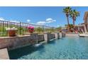 Sparkling pool featuring elegant waterfall features, lush greenery, and palm trees at 2539 Turtle Head Peak Dr, Las Vegas, NV 89135