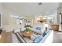 Bright, staged living room with white furniture, light wood floors, and an open layout at 2601 Deer Lake St, Las Vegas, NV 89134