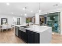 Spacious kitchen island with a stainless steel sink, modern fixtures, and an open view of living spaces at 2710 Marchetti Pl, Henderson, NV 89044